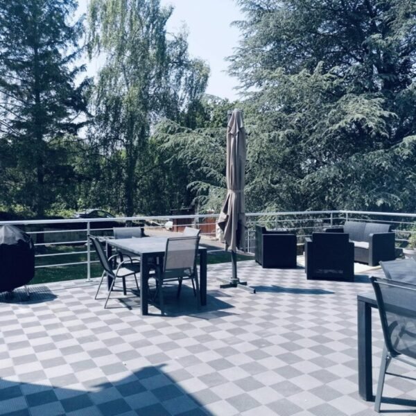 La terrasse avec barbecue, salon de jardin et parasols des Gîtes Le Chêne Pommier à Fatouville-Grestain dans l'Eure en Normandie