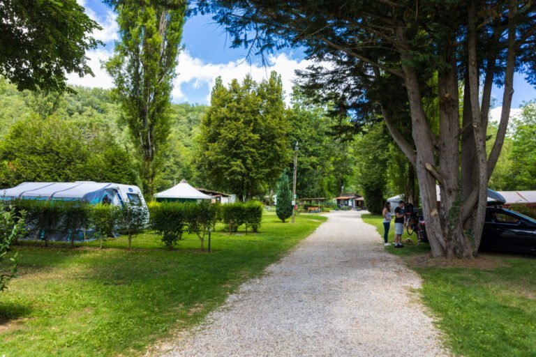 Une allée d'emplacemnt camping du Camping d'Auberoche à Bassilac et Auberoche en Dordogne en Nouvelle-Aquitaine