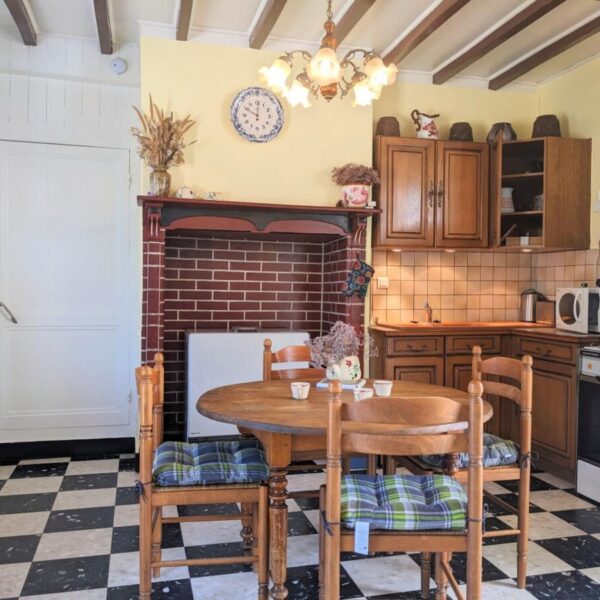 Cuisine équipé et table avec chaises au Gîte - Un Brin d'Espoir à Fort Mahon Plage à Somme en Hauts de France