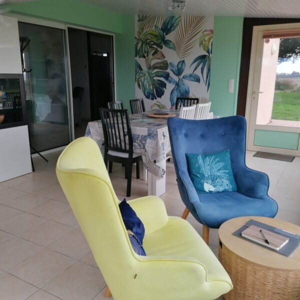 Véranda avec une table et des chaises chez Gîte Mont Magique à Dragey Ronthon dans la Manche, Normandie