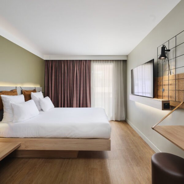 Chambre avec double lit et télévision à l'Hôtel Moxy Annecy à Annecy en Haute-Savoie dans l'Auvergne-Rhône-Alpes